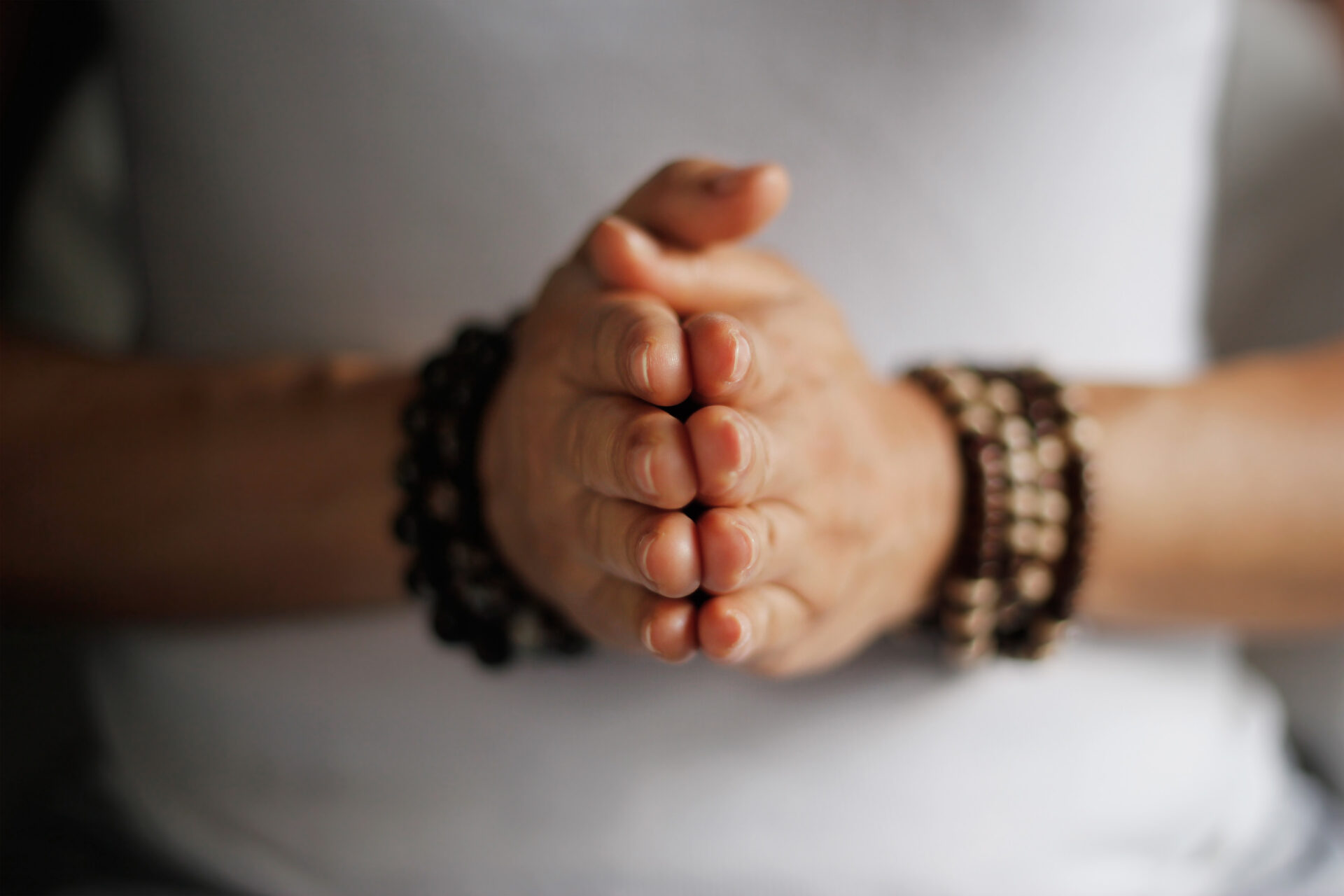 Woman hand yoga pose. Practicing meditation and praying indoors. Frau in einer Yoga-Pose. Sie meditiert und betet in einem Innenraum.